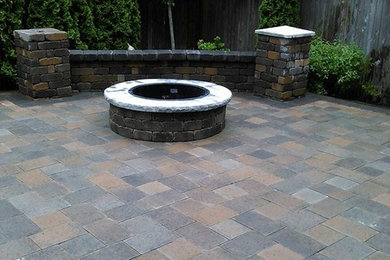 Large transitional backyard patio in Seattle with a fire feature and concrete pavers.