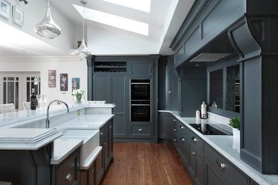 This is an example of a large transitional l-shaped eat-in kitchen in Other with raised-panel cabinets, grey cabinets, quartzite benchtops, mirror splashback, panelled appliances, medium hardwood floors and brown floor.