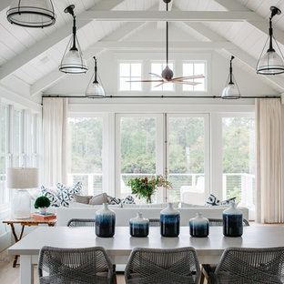 Mid-sized coastal light wood floor and beige floor dining room photo in Charleston with white walls, a standard fireplace and a stone fireplace