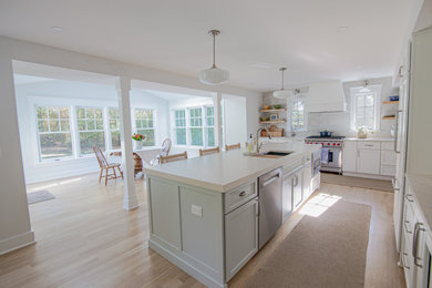 Kitchen - coastal light wood floor kitchen idea in Philadelphia with shaker cabinets, white cabinets, quartz countertops, an island and white countertops