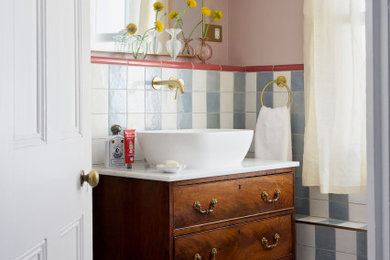 Design ideas for a victorian bathroom in London with flat-panel cabinets, dark wood cabinets, multi-coloured tiles, pink walls, a vessel sink, grey floors, white worktops, a single sink and a freestanding vanity unit.