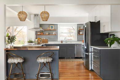 Example of a mid-sized 1950s u-shaped medium tone wood floor eat-in kitchen design in Minneapolis with a double-bowl sink, flat-panel cabinets, gray cabinets, quartz countertops, gray backsplash, stainless steel appliances, an island and white countertops