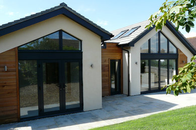 Photo of a medium sized and white contemporary bungalow detached house in Berkshire with mixed cladding, a pitched roof and a tiled roof.