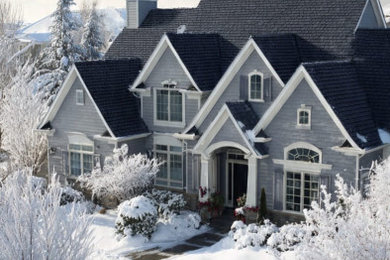 Mid-sized traditional gray two-story vinyl and clapboard house exterior idea in New York with a hip roof, a shingle roof and a black roof
