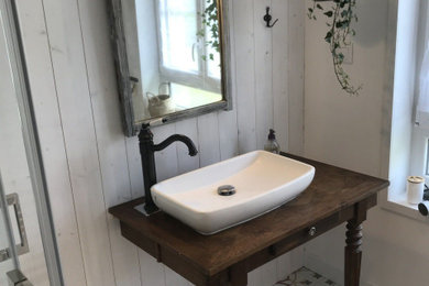 Diseño de cuarto de baño blanco y madera de estilo de casa de campo pequeño con ducha esquinera, sanitario de una pieza, paredes blancas, aseo y ducha y encimera de madera