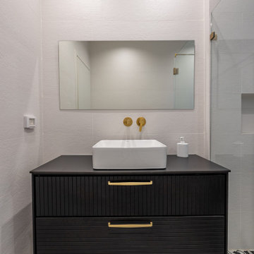 Black guest bathroom with patterned floor tile