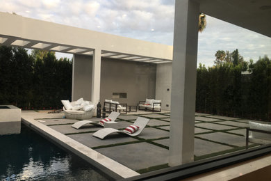 Diseño de piscinas y jacuzzis naturales modernos de tamaño medio rectangulares en patio trasero con losas de hormigón