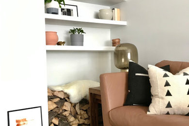This is an example of a medium sized scandinavian enclosed living room in Other with white walls, porcelain flooring, a standard fireplace, a wall mounted tv and brown floors.