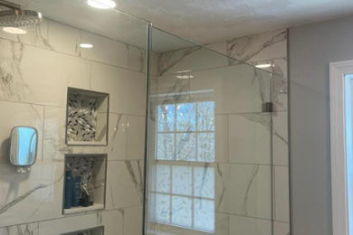 Example of a large minimalist master white tile and stone tile wet room design in Boston with gray walls and a hinged shower door