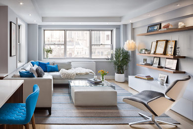 Inspiration for a contemporary open concept light wood floor living room remodel in New York with gray walls and a wall-mounted tv
