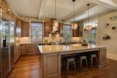 Photo of a traditional l-shaped kitchen in New Orleans with an undermount sink, beaded inset cabinets, medium wood cabinets, granite benchtops, stainless steel appliances and with island.