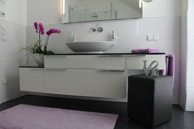 Großes Modernes Duschbad mit offenen Schränken, Einbaubadewanne, bodengleicher Dusche, Wandtoilette, weißen Fliesen, Porzellanfliesen, weißer Wandfarbe, Zementfliesen für Boden, Aufsatzwaschbecken, Waschtisch aus Holz, schwarzem Boden und offener Dusche in Bonn