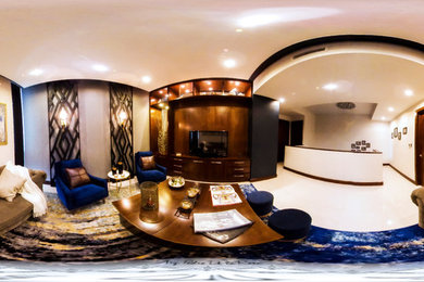 Modelo de sala de estar abierta bohemia de tamaño medio sin chimenea con paredes grises, pared multimedia y suelo azul