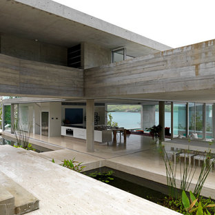 タウンズビルの巨大なインダストリアルスタイルのLDKの画像 (グレーの壁、コンクリートの床、暖炉なし、ベージュの床)