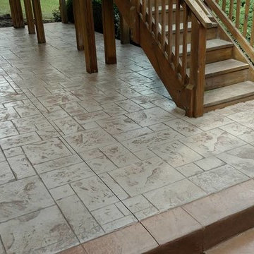 J-Stamped concrete patio with a step under the wood deck