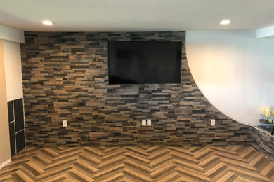 Living room - large modern open concept medium tone wood floor, brown floor and brick wall living room idea in Orlando with white walls and a wall-mounted tv