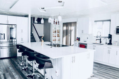 Example of a large minimalist galley vinyl floor, gray floor and wood ceiling eat-in kitchen design with an undermount sink, recessed-panel cabinets, white cabinets, quartz countertops, multicolored backsplash, porcelain backsplash, stainless steel appliances, an island and white countertops