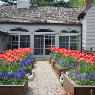 Traditional courtyard full sun garden in New York with gravel and with raised garden bed for spring.