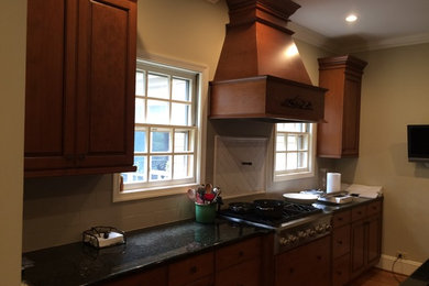 Imagen de cocina comedor clásica con armarios con paneles con relieve, encimera de granito y suelo de madera clara