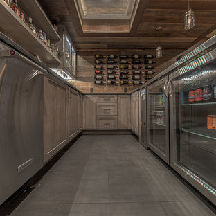 Diseño de sótano en el subsuelo rústico, grande, con paredes marrones, chimeneas suspendidas, marco de chimenea de baldosas y/o azulejos, suelo de baldosas de porcelana y suelo gris