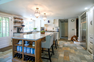 Eat-in kitchen - large traditional l-shaped gray floor eat-in kitchen idea in Boston with a farmhouse sink, recessed-panel cabinets, white cabinets, marble countertops, white backsplash, marble backsplash, stainless steel appliances, an island and white countertops