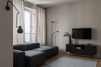 Источник вдохновения для домашнего уюта: гостиная комната в современном стиле с серыми стенами, светлым паркетным полом, телевизором и зоной отдыха