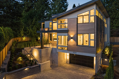 Large contemporary wood house exterior idea in Seattle with a black roof