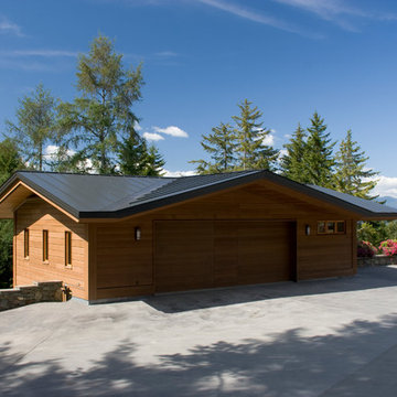 New garage with radiant heated driveway and stone stairs to lawn and patio area
