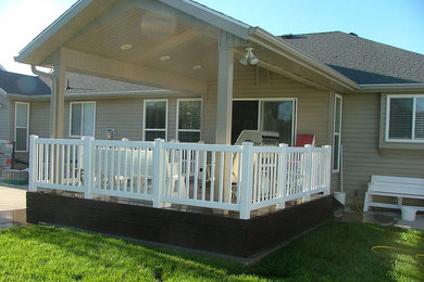 Small elegant backyard outdoor kitchen deck photo in Salt Lake City with a roof extension