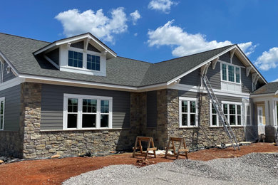 Mid-sized one-story mixed siding exterior home photo in Other with a shingle roof