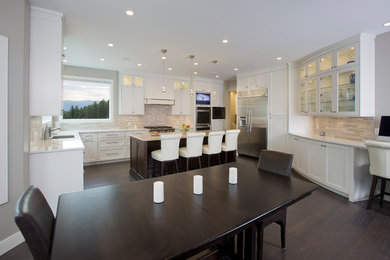 Inspiration for a large transitional eat-in kitchen in Vancouver with an undermount sink, shaker cabinets, white cabinets, quartzite benchtops, beige splashback, mosaic tile splashback, stainless steel appliances, dark hardwood floors and with island.
