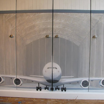 Mural of airplane in hanger painted on toy storage piece