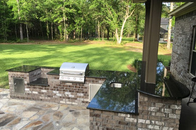 Patio kitchen - mid-sized traditional backyard stone patio kitchen idea in Miami with no cover