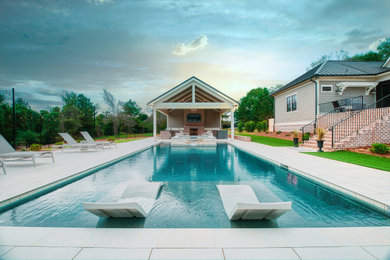Diseño de piscina rectangular en patio trasero con suelo de baldosas