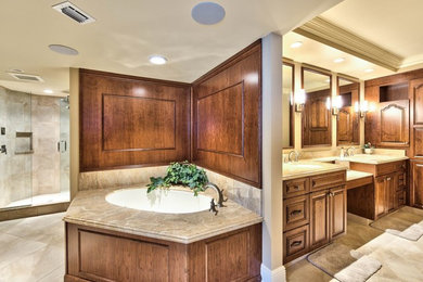 Photo of a large traditional master bathroom in Miami with raised-panel cabinets, medium wood cabinets, beige tile, porcelain tile, beige walls, porcelain floors, an undermount sink, granite benchtops and a drop-in tub.