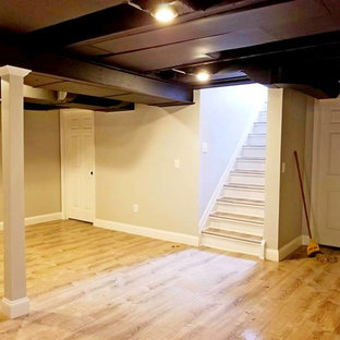 This is an example of a large traditional fully buried basement in Detroit with beige walls, laminate floors, no fireplace and beige floors.