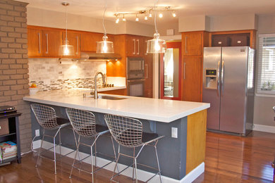 Eat-in kitchen - mid-sized contemporary l-shaped medium tone wood floor eat-in kitchen idea in San Francisco with a single-bowl sink, flat-panel cabinets, medium tone wood cabinets, quartzite countertops, multicolored backsplash, matchstick tile backsplash, stainless steel appliances and a peninsula