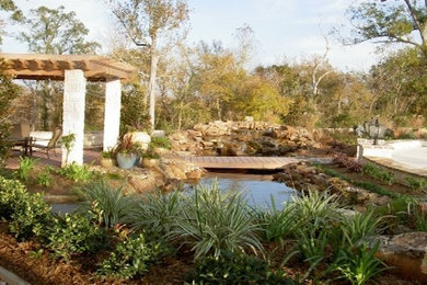 Photo of a large full sun backyard water fountain landscape in Houston.