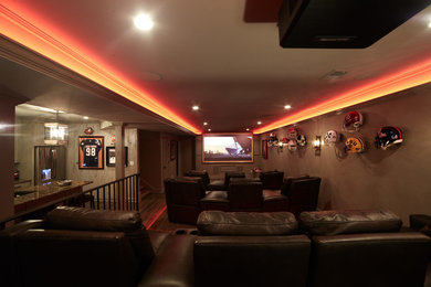 Cette photo montre une salle de cinéma tendance de taille moyenne et fermée avec un mur beige, moquette et un écran de projection.