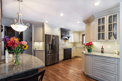 Large elegant u-shaped dark wood floor and brown floor eat-in kitchen photo in Other with raised-panel cabinets, stainless steel appliances, no island, an undermount sink, granite countertops, subway tile backsplash, black cabinets and beige backsplash