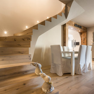 Ejemplo de escalera curva, rural, de tamaño medio, con escalones de madera y contrahuellas de madera