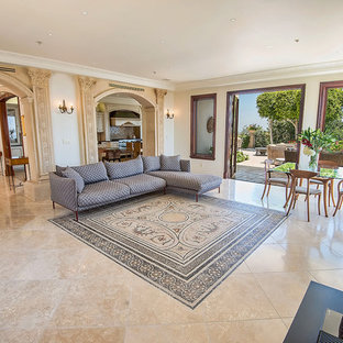 Ejemplo de salón abierto, mediterráneo, extra grande, con paredes multicolor, suelo de mármol, chimenea tradicional, marco de chimenea de hormigón, televisor colgado en la pared y suelo multicolor
