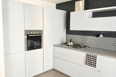 Photo of a mid-sized modern l-shaped eat-in kitchen in Other with quartzite benchtops, grey splashback, porcelain floors and grey benchtop.