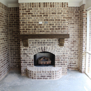 Fireplace with rustic mantle on sceened in porch