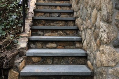 Photo of a mid-sized transitional partial sun backyard concrete paver retaining wall landscape in New York.