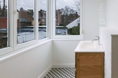 Réalisation d'une douche en alcôve design avec un carrelage blanc, un carrelage métro, un plan de toilette en surface solide, un mur blanc, carreaux de ciment au sol, un plan vasque et un sol multicolore.