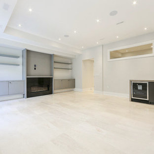 Photo of a large traditional walk-out basement in Toronto with white walls, marble flooring, a standard fireplace, a stone fireplace surround and beige floors.