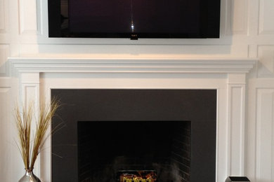 Inspiration for a modern medium tone wood floor living room remodel in New York with white walls, a stone fireplace and a wall-mounted tv