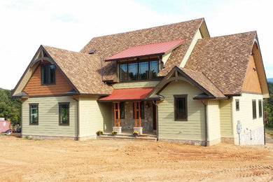 Large craftsman green two-story concrete fiberboard exterior home idea in DC Metro with a mixed material roof