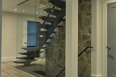 Design ideas for a mid-sized modern wood straight staircase in Toronto with open risers and metal railing.